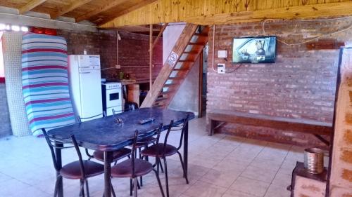 a table and chairs in a kitchen with a staircase at Las hortensias in El Hoyo