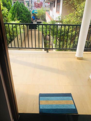 alfombra azul en un balcón con barandilla en Akesha's House, en Weligama