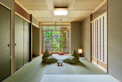 a room with two pillows on the floor with a window at Choya Chawanzaka Machiya House in Kyoto