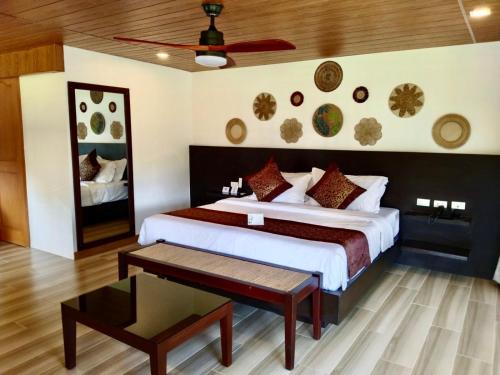 1 dormitorio con 1 cama grande y 1 mesa en Commander Suites de Bohol, en Panglao