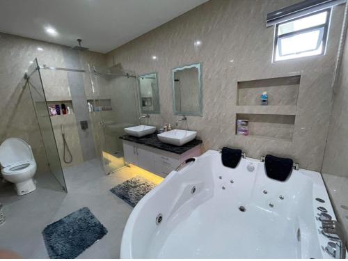 a bathroom with a tub and a toilet and a sink at Villa Tobias San Juan Batangas in Batangas City