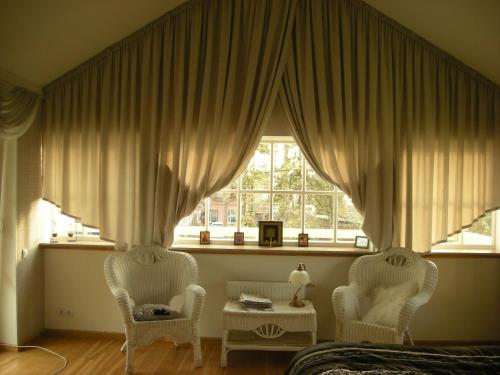 ユールマラにあるDzintarsの窓のある部屋に椅子2脚とテーブル1台