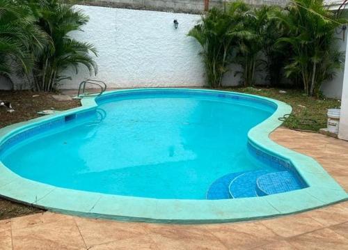 une grande piscine bleue en face d'un bâtiment dans l'établissement La Mezcla Perfecta Hostal, à Managua