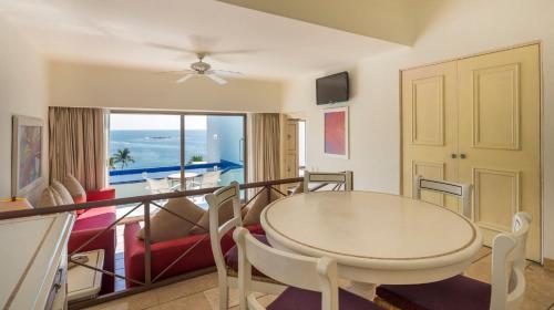 a dining room and living room with a table and chairs at Camino Real Zaashila Huatulco in Santa Cruz Huatulco