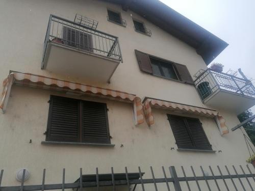 a white building with windows and a fence at Chez Papi - A 5 min da piste da Sci e Stazione CIR VDA AO 0013 in Aosta