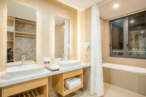 un bagno con 2 lavandini e una vasca di Diora Hotel a Pleiku