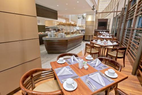 a restaurant with wooden tables and chairs and a counter at Sheraton Guayaquil in Guayaquil