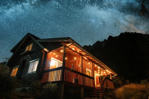 a cabin lit up at night with lights on it at 森のや in Shimo-sagano