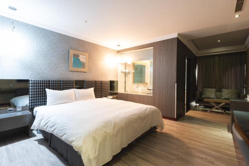 a hotel room with a large bed and a bathroom at Shianghu Boutique Hotel in Chiayi City