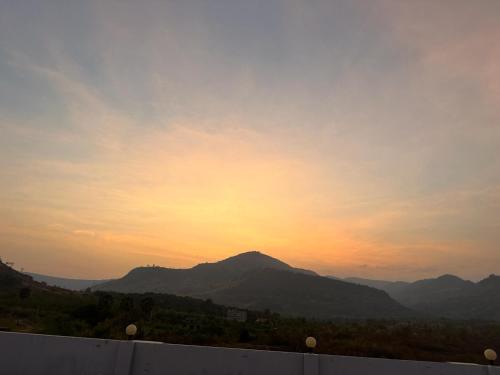 a view of a sunset with mountains in the background at The Vibe Guesthouse in Kampot