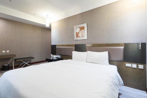 a large white bed in a hotel room at Shianghu Boutique Hotel in Chiayi City