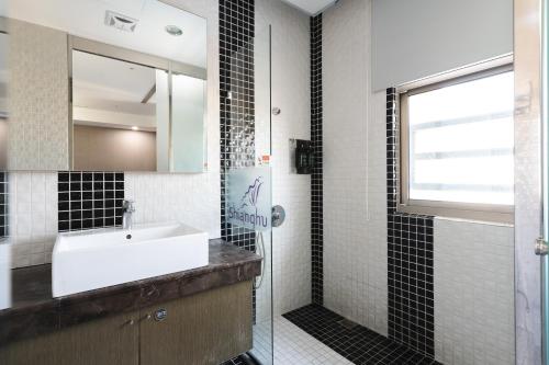 a bathroom with a sink and a shower at Shianghu Boutique Hotel in Chiayi City