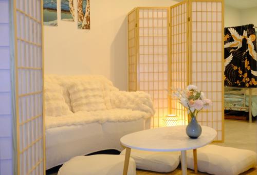 una habitación con una cama y una mesa con un jarrón de flores en Japanese Penthouse Retreat 1B1B 2 Parking 5-min tram-to-CBD Brekky Wifi Netflix en Canberra