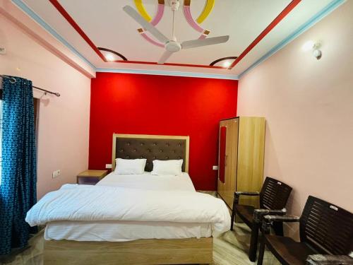 una camera con un letto con una parete rossa di Goswami Guest House a Faizābād