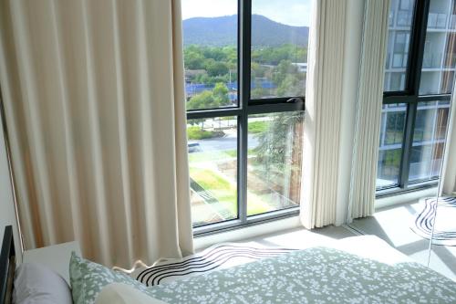 a bedroom with a large window with a view at Japanese Penthouse Retreat 1B1B 2 Parking 5-min tram-to-CBD Brekky Wifi Netflix in Canberra