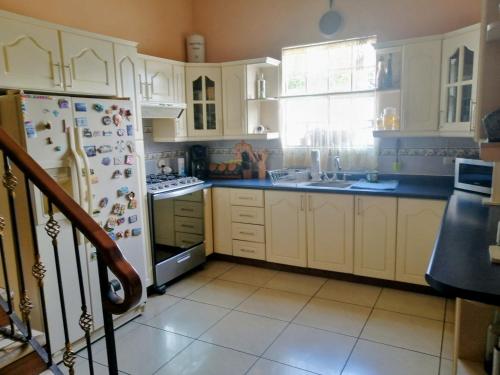 a kitchen with white cabinets and a refrigerator at Las Marias House in Choacorral