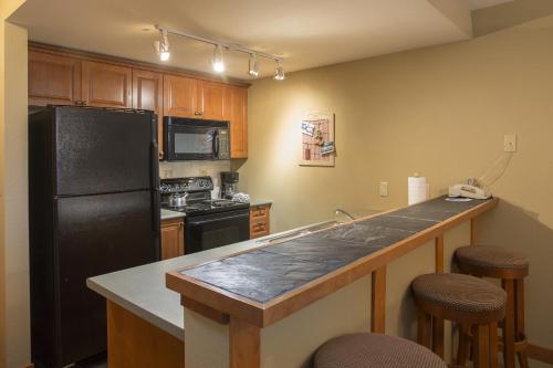 a kitchen with a black refrigerator and a counter at 1310 - One Bedroom Den Standard Eagle Springs West condo in Solitude