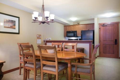 a kitchen and dining room with a wooden table and chairs at 2203 - One Bedroom Den Standard Eagle Springs East condo in Solitude