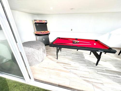 a red pool table in a room with a chair at Golden sunset 2 in Popotla