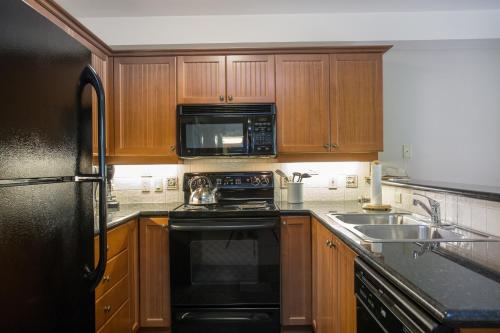 a kitchen with wooden cabinets and a black appliance at 2312 - Two Bedroom Den Standard Eagle Springs East condo in Solitude