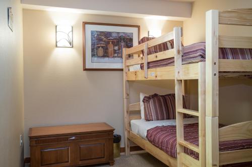 a bedroom with two bunk beds and a table at 3406 - One Bedroom Den Standard Powderhorn Lodge condo in Solitude