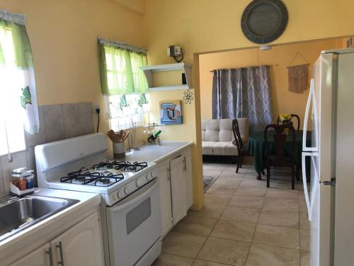 uma cozinha com um fogão e um lavatório em Patrickville em Gwa Kay