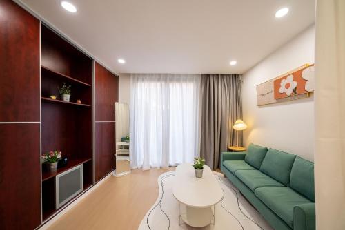 a living room with a green couch and a table at 一抹云栖世博店-公寓民宿 Bed and Breakfast in Shanghai