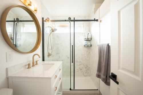 La salle de bains est pourvue d'une douche, d'un lavabo et d'un miroir. dans l'établissement Luxury Disneyland Home: Family & Exec Friendly, à Anaheim