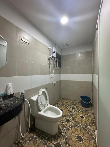 a bathroom with a toilet and a shower at Grand Line Hotel Semporna in Semporna