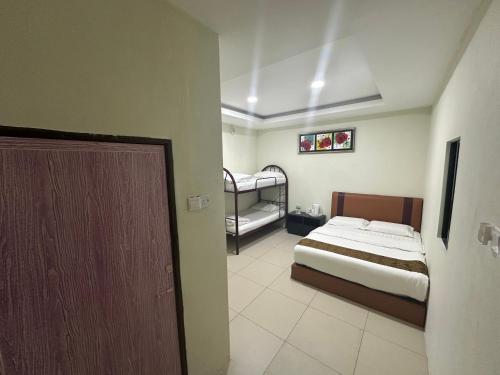 a bedroom with a bed and two bunk beds at Grand Line Hotel Semporna in Semporna