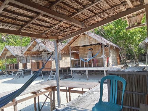 a group of huts with a hammock and a table and chairs at byuk Beya homestay in Kri