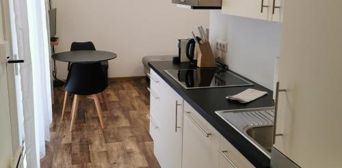 a small kitchen with a sink and a table at Lodge Hochwipfel mit Self-Check-In in Oberdöbernitzen