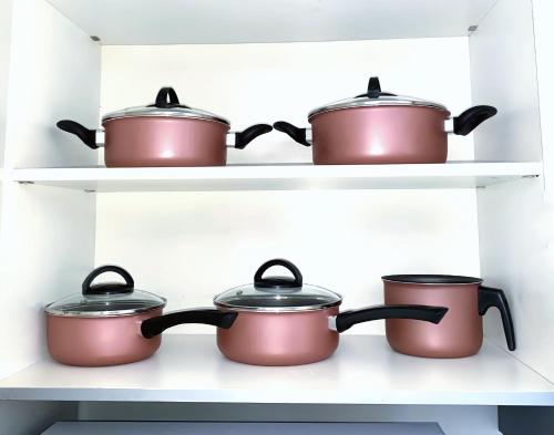 four pots and pans on shelves in a kitchen at FLAT Boa Viagem - 50m da Praia - Garagem GRÁTIS - 24H CHECK IN - in Recife