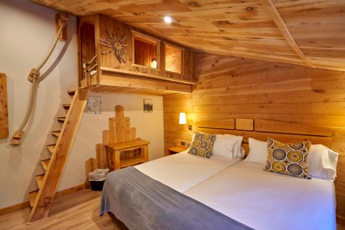 una camera con un letto in una baita di tronchi di Coma Bella a Sant Julià de Lòria