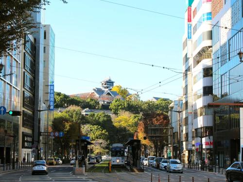 a city street with cars and a bus at Grids Premium Hotel Kumamoto in Kumamoto