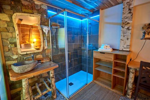 a bathroom with a shower with a stone wall at Coma Bella in Sant Julià de Lòria