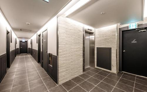 a hallway with black doors and a tile floor at Hotel Venesian in Pohang