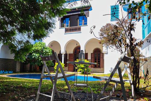 two chairs and a table in front of a building at Riad Tazi Casablanca in Casablanca