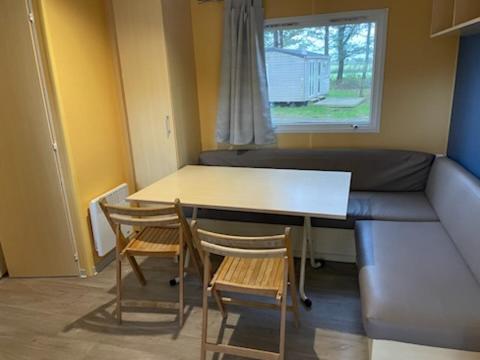 een kamer met een tafel en stoelen en een bank bij PUY DU FOU 6P F028 in La Boissière-de-Montaigu