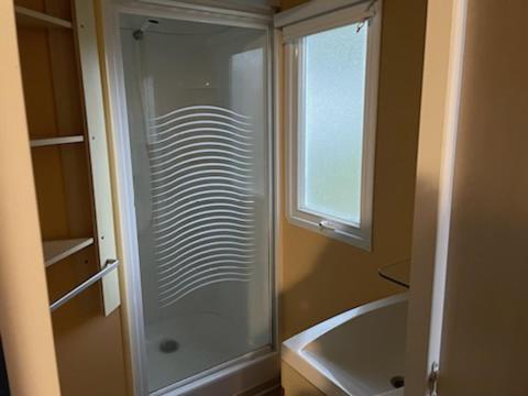 een badkamer met een douche en een bad en een raam bij PUY DU FOU 6P F028 in La Boissière-de-Montaigu