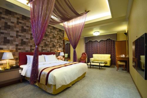 um quarto com uma cama grande e cortinas roxas em Summer House Motel em Tainan