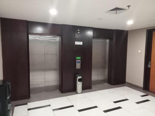 einen Flur mit zwei Aufzügen in einem Gebäude in der Unterkunft LYNT Hotel in Jakarta