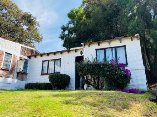 an old white house with flowers in the yard at Club Santa Maria in Cuernavaca