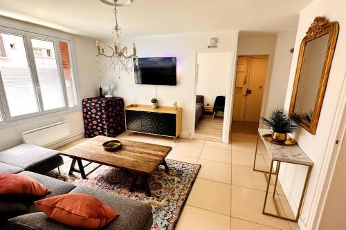 uma sala de estar com um sofá e uma mesa em Appartement 3 chambres + parking à Lyon 7 em Lyon