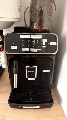 - une cafetière avec un ordinateur portable dans l'établissement Appartement 3 chambres + parking à Lyon 7, à Lyon