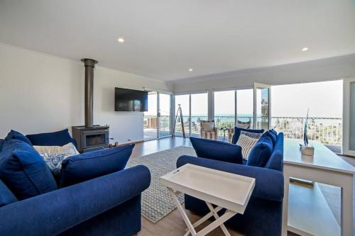 a living room with blue chairs and a fireplace at Uninterrupted Views Encounter Bay - BYO Linen in Encounter Bay