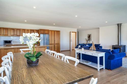 a living room with a table and a blue couch at Uninterrupted Views Encounter Bay - BYO Linen in Encounter Bay