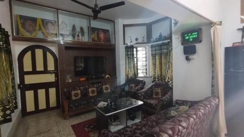 a living room with a couch and a tv at House of Rabindra Kumar in Deoghar
