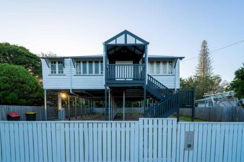 a house with a staircase in front of a fence at Relaxing 5B2BHome w Parking Walk to Brisbane River in Brisbane