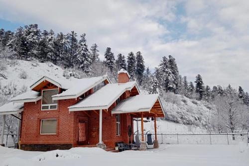 a house with snow on the roof at StayVista at Suroor with Central Heating in Tangmarg in Tangmarg